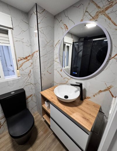 Baño reformado con azulejo efecto mármol y lavabo suspendido